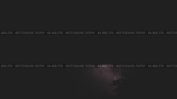 По темному ночному небу проносятся молнии самых разных форм, озаряя облака короткими вспышками света. Ночная гроза. Стоковое видео, видеограф Воловодов Владимир / Фотобанк Лори