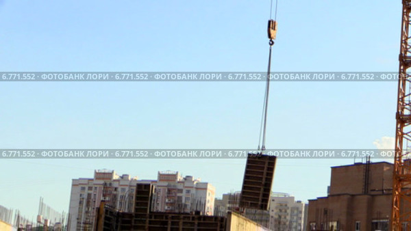 Подъемный кран опускает опалубку на строительной площадке. Стоковое видео, видеограф Арташес Оганджанян / Фотобанк Лори