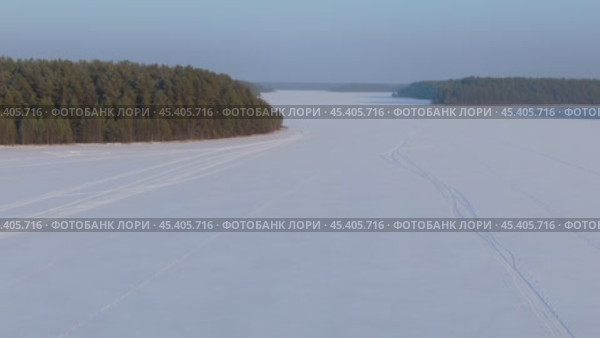 Полёт над зимним озером и лесом. Стоковое видео, видеограф Денис Логиновский / Фотобанк Лори