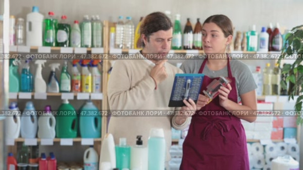 Polite young female sales assistant of personal care department talking friendly and offering options of safety razors to hesitant male customer. Стоковое видео, видеограф Яков Филимонов / Фотобанк Лори