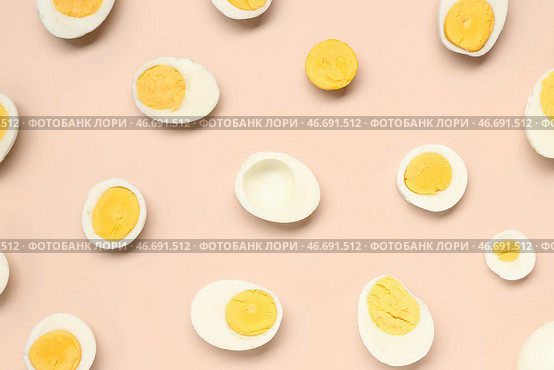 Половинки вкусных отваренных яиц с ломтиками на розовом фоне. Стоковое фото, фотограф Pixel_shot / Фотобанк Лори