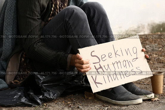 Poor homeless man holding cardboard with text SEEKING HUMAN KINDNESS outdoors. Стоковое фото, фотограф Pixel_shot / Фотобанк Лори