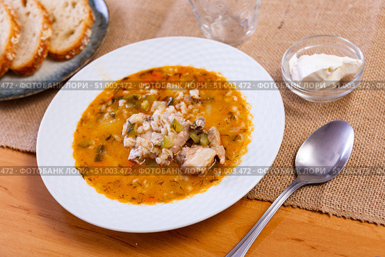Popular dish of Russian cuisine is pickle soup with meat, cooked on basis of pickled cucumbers and pearl barley or rice, decorated with sprig of parsley. Стоковое фото, фотограф Яков Филимонов / Фотобанк Лори