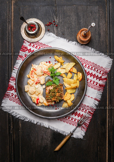 Pork loin steaks with herbs crust, roast potatoes and salsa sauce in rustic plate , top view. Стоковое фото, агентство Ingram Publishing / Фотобанк Лори