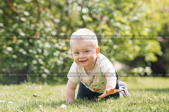 Portrait of a 1-year-old little boy outdoors. A happy child walks in the spring park. Happy childhood and fatherhood. Стоковое фото, фотограф Photojuli / Фотобанк Лори