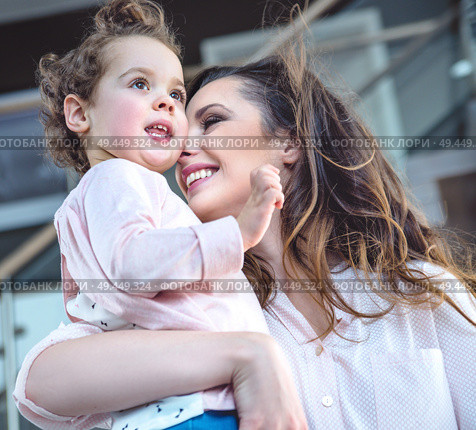 Portrait of a cheerful mom cuddling beloved daughter. Стоковое фото, агентство Ingram Publishing / Фотобанк Лори