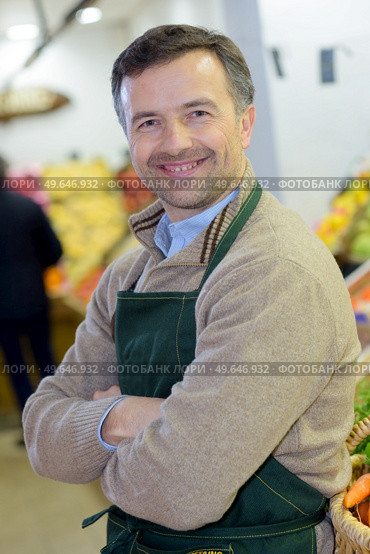 portrait of a handsome seller with arms crossed in supermarket. Стоковое фото, агентство Ingram Publishing / Фотобанк Лори