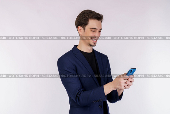 Portrait of a happy businessman using smartphone over white background. Using mobile phone, typing sms message. Стоковое фото, агентство Ingram Publishing / Фотобанк Лори