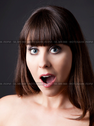 Portrait of a lovely woman with a astonish expression against a grey background . Стоковое фото, агентство Ingram Publishing / Фотобанк Лори