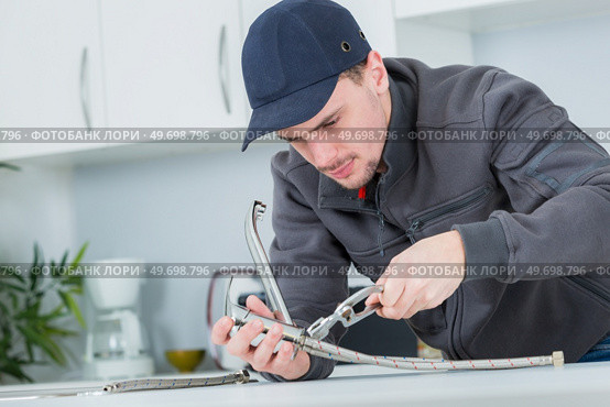 portrait of a male worker replacing the taps connection. Стоковое фото, агентство Ingram Publishing / Фотобанк Лори