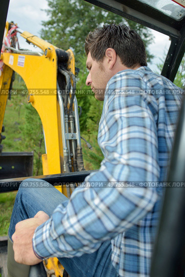 portrait of a man controlling digger bucket. Стоковое фото, агентство Ingram Publishing / Фотобанк Лори