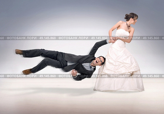 Portrait of a stubborn, young bride holding a groom. Стоковое фото, агентство Ingram Publishing / Фотобанк Лори