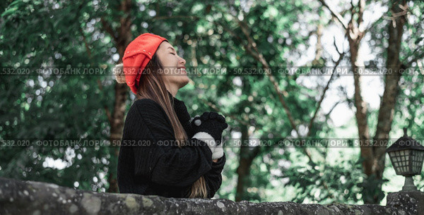 Portrait of Asian young woman in winter costume praying in the morning at the woodland. Christianity and faith hope love concept. Стоковое фото, агентство Ingram Publishing / Фотобанк Лори