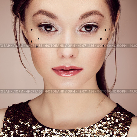 Portrait of beautiful young woman in a shiny golden dress. Brunette girl. Perfect make-up. Freckles. Стоковое фото, агентство Ingram Publishing / Фотобанк Лори