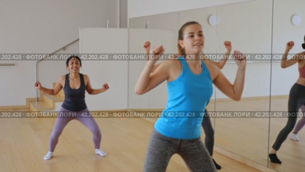 Portrait of cheerful girl practicing vigorous jive movements in group dance class. Стоковое видео, видеограф Яков Филимонов / Фотобанк Лори