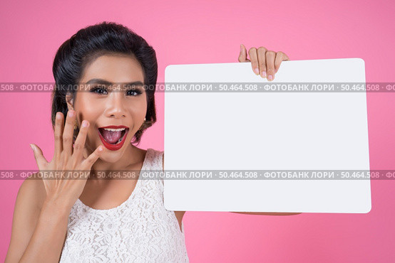 Portrait of fashion woman displaying white banner. Стоковое фото, агентство Ingram Publishing / Фотобанк Лори