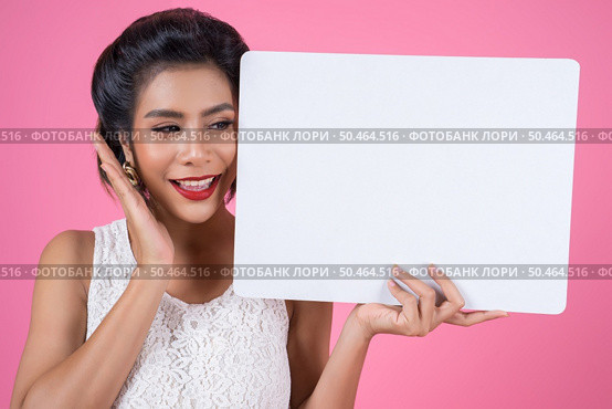 Portrait of fashion woman displaying white banner. Стоковое фото, агентство Ingram Publishing / Фотобанк Лори