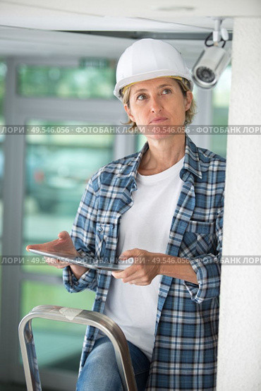 portrait of female cctv installer. Стоковое фото, агентство Ingram Publishing / Фотобанк Лори