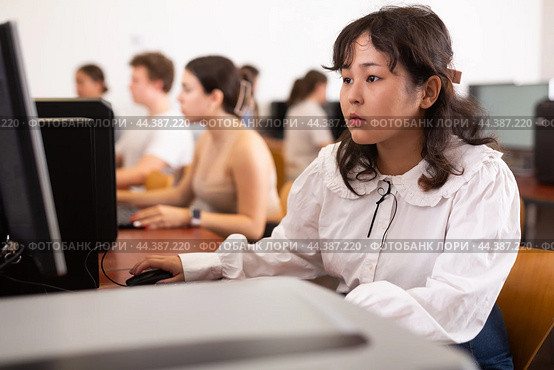 Portrait of fifteen-year-old schoolgirl studying at computer in class at an informatics lesson with classmates. Стоковое фото, фотограф Яков Филимонов / Фотобанк Лори