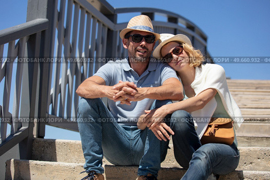 portrait of happy couple sitting together on staircase in embrace. Стоковое фото, агентство Ingram Publishing / Фотобанк Лори