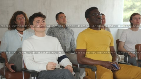 Portrait of interested adult man attentively listening to lecture, sitting in auditorium full of male students. Стоковое видео, видеограф Яков Филимонов / Фотобанк Лори