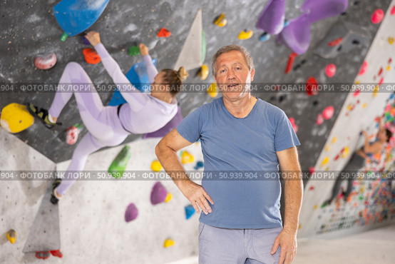 Portrait of positive elderly male coach against background of climbing wall. Стоковое фото, фотограф Яков Филимонов / Фотобанк Лори