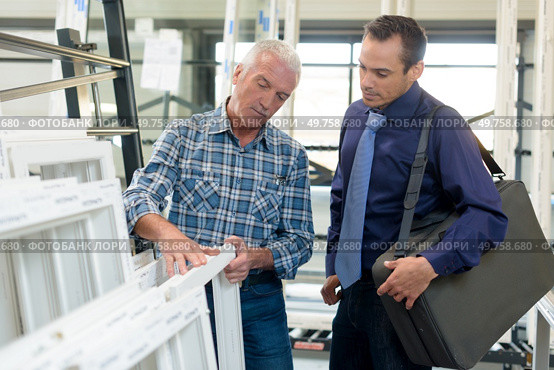 portrait of smiling satisfied worker at pvc windows factory. Стоковое фото, агентство Ingram Publishing / Фотобанк Лори