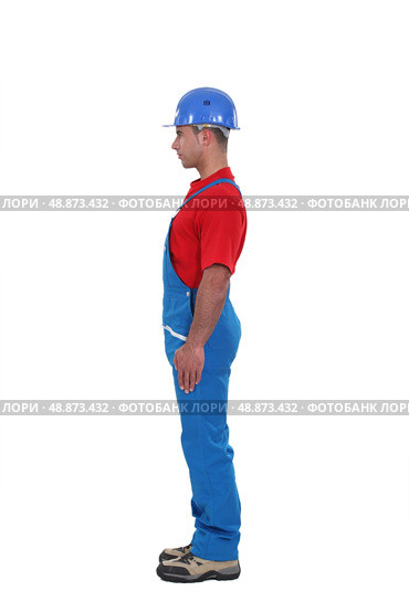 portrait of young craftsman standing in profile against studio background. Стоковое фото, агентство Ingram Publishing / Фотобанк Лори