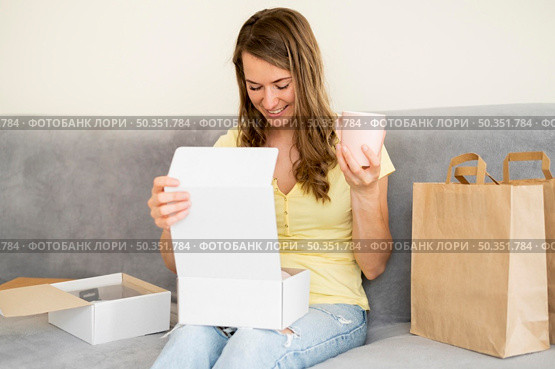 portrait woman unboxing products ordered. Стоковое фото, агентство Ingram Publishing / Фотобанк Лори