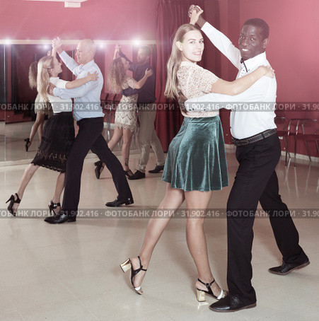 Positive adult couples dancing tango together in modern studio. Стоковое фото, фотограф Яков Филимонов / Фотобанк Лори