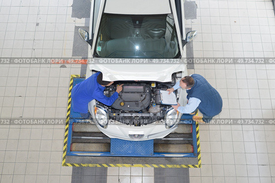 positive mechanics fixing car. Стоковое фото, агентство Ingram Publishing / Фотобанк Лори