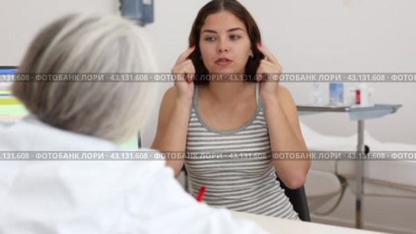 Positive young woman patient discussing face aesthetic procedures with a specialist in doctor's cabinet. Стоковое видео, видеограф Яков Филимонов / Фотобанк Лори