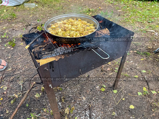 Pot of food is cooking on a fire. Стоковое фото, фотограф Олег Спиридонов / Фотобанк Лори