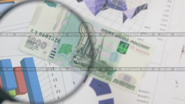 Повертите в руках тысячу рублей и увеличьте с помощью увеличительного стекла. Вид сверху. Стоковое видео, видеограф Александр Собко / Фотобанк Лори