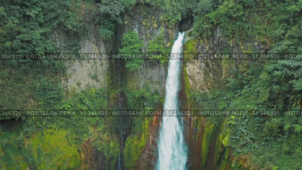 Powerful waterfall Catarata del Toro drops into pool surrounded by mossy rocks in Costa Rica. Стоковое видео, видеограф Igor Tichonow / Фотобанк Лори