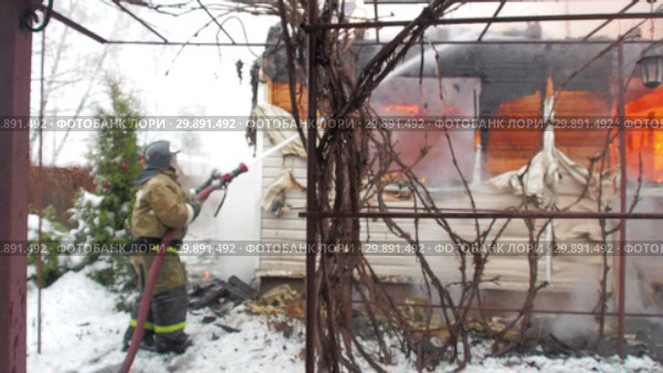 Пожар зимой в СНТ. Пожарный тушит горящий щитовой дом. Видео в расфокусе. Стоковое видео, видеограф Сайганов Александр / Фотобанк Лори