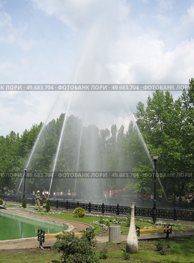 Пожарные в форме распыляют воду, водяная арка в городском парке (2008 год). Редакционное фото, фотограф Snezka / Фотобанк Лори