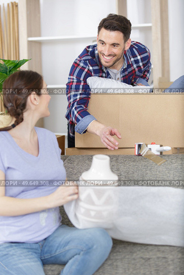 pregnant couple unpacking possessions in their new family home. Стоковое фото, агентство Ingram Publishing / Фотобанк Лори