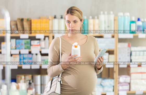 Pregnant woman choosing cream in drugstore. Стоковое фото, фотограф Яков Филимонов / Фотобанк Лори