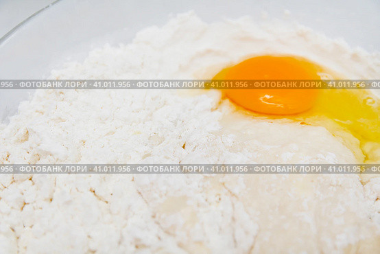 Preparation of the yeast dough. Dough with the egg`s yolk and flavour in the glass bowl is ready to be stirred. Приготовление дрожжевого теста. Тесто с яичным желтком и ароматизатором в стеклянной миске готово к перемешиванию. Стоковое фото, фотограф Дмитрий Березнев / Фотобанк Лори