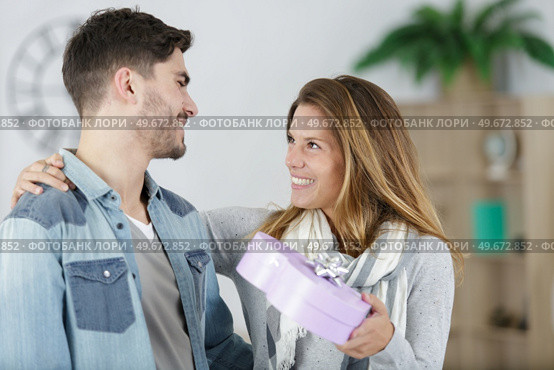 pretty woman surprising her boyfriend with gift. Стоковое фото, агентство Ingram Publishing / Фотобанк Лори