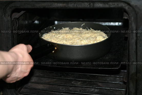 Приготовление мясных рулетиков, руки ставят сковороду в духовку плиты. Стоковое фото, фотограф Fro / Фотобанк Лори