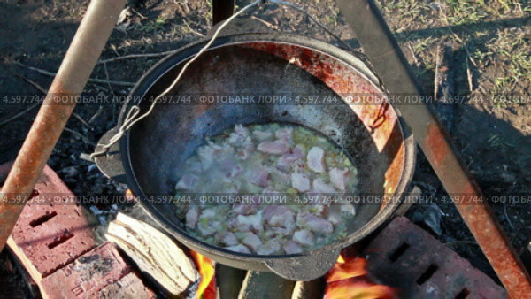 Приготовление плова, тушится мясо. Стоковое видео, видеограф Никита Майков / Фотобанк Лори