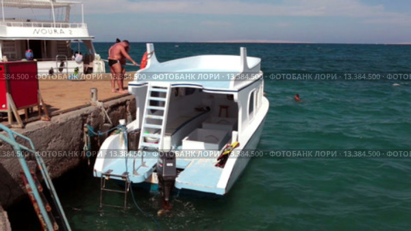 Пришвартованный к пирсу катер болтается на морских волнах. Красное море, Хургада, Египет (2015 год). Редакционное видео, видеограф Кекяляйнен Андрей / Фотобанк Лори