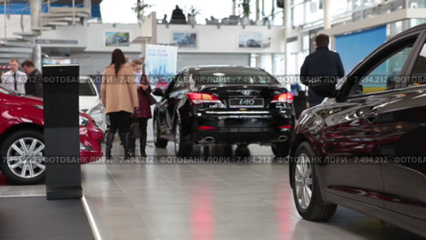 Продавец с покупателями в шоуруме с новыми автомобилями Хендай на продажу (2015 год). Редакционное видео, видеограф Кекяляйнен Андрей / Фотобанк Лори