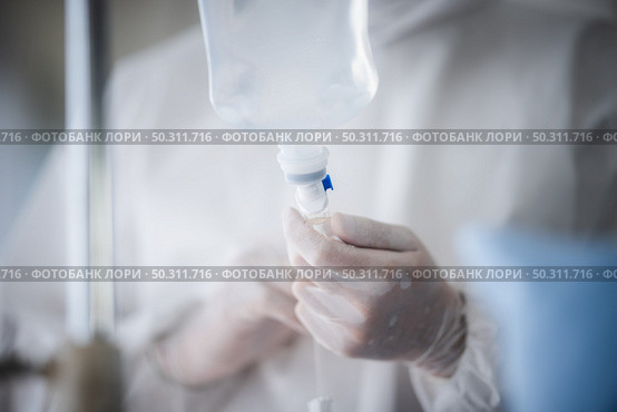 professional doctor and nurse are wearing PPE suit protection and looking for coronavirus covid-19 virus infected patient’s in hospital laboratory. Стоковое фото, агентство Ingram Publishing / Фотобанк Лори