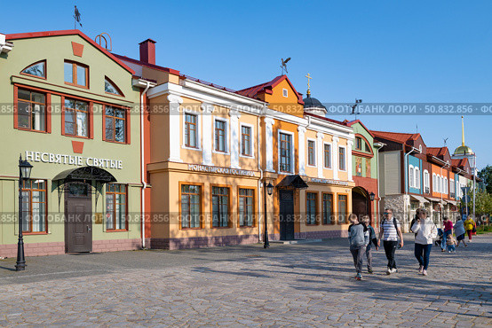 Прогулка по городской улице солнечным июньским днем. Печоры, Псковская область. Редакционное фото, фотограф Виктор Карасев / Фотобанк Лори