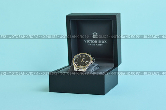 Pskov, Russia, August 03. 2022. Close up fashion image of Victorinox watch in a black box on a blue background. Редакционное фото, фотограф Ирина Старикова / Фотобанк Лори