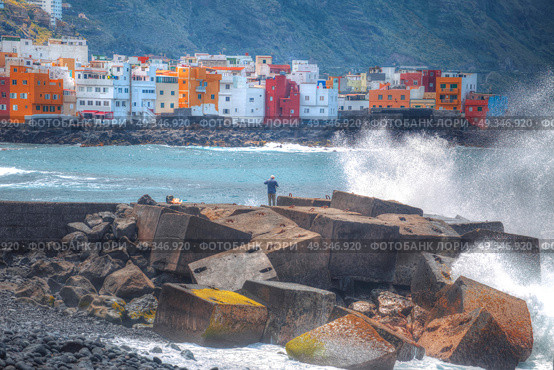Puerto de la Cruz. fisherman standing on the dock and goes fishing. Big waves. Стоковое фото, агентство Ingram Publishing / Фотобанк Лори