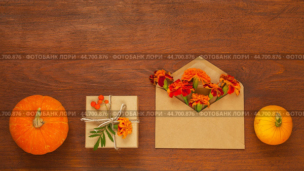 Pumpkins, marigolds, handmade gifts on old wooden background. Beautiful blank for congratulations on autumn holiday, on Thanksgiving, on Halloween or beginning of autumn. Flat lay, copy space, mock up. Стоковое фото, фотограф Виктория Катьянова / Фотобанк Лори